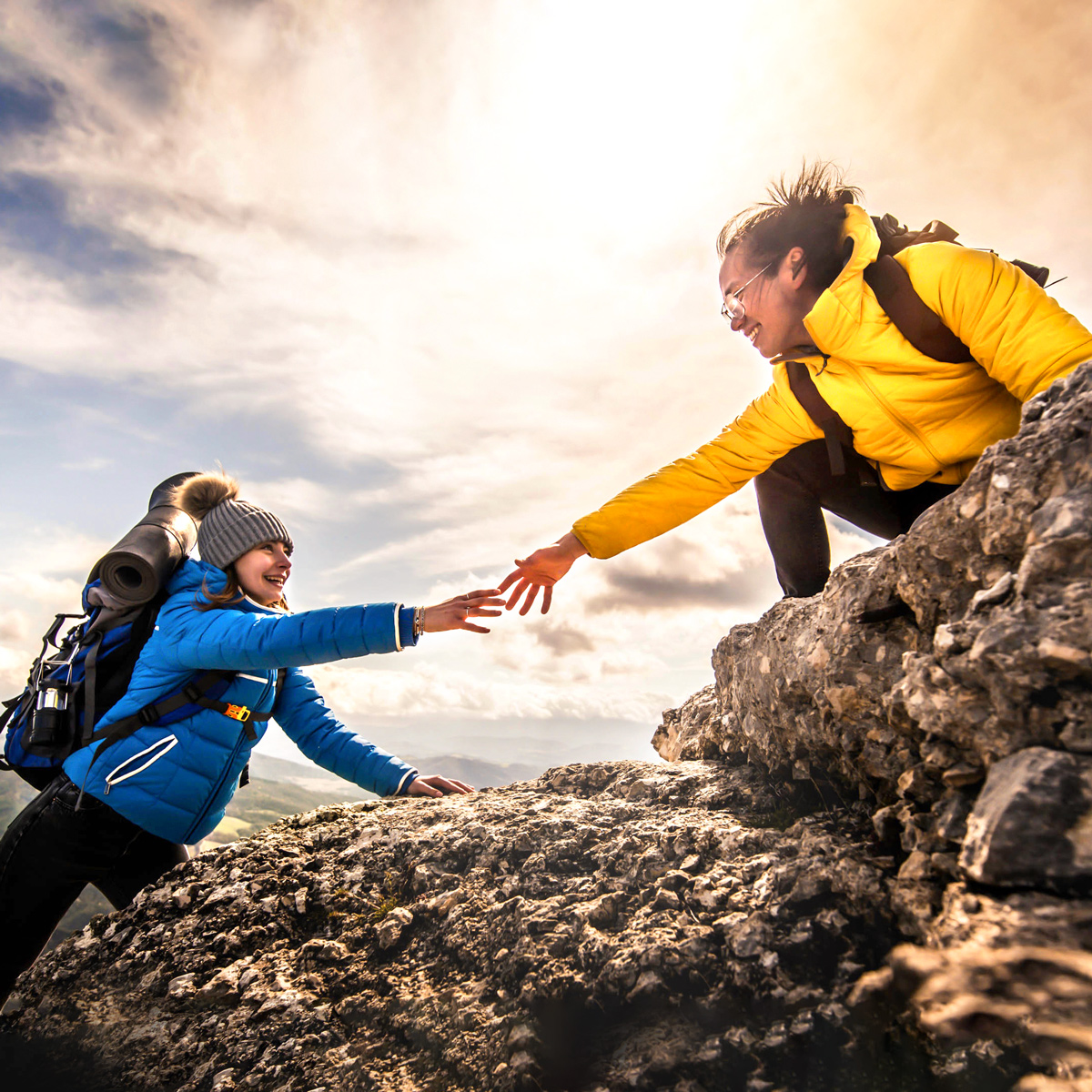 Zwei Frauen beim Bergsteigen helfen einander